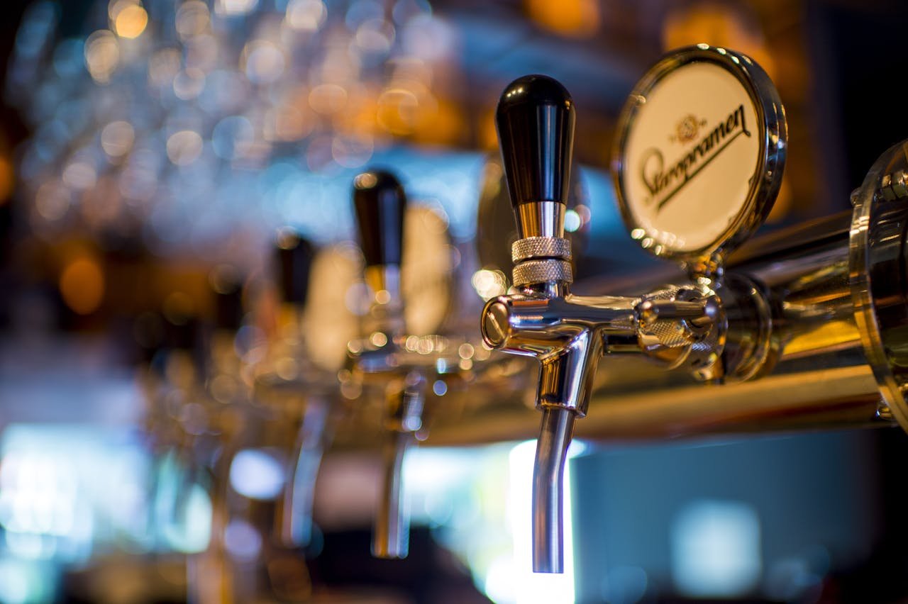 Servicios Bar Los Luises en Montanejos. Focused image of a shiny beer tap in a stylish bar with a blurred background.